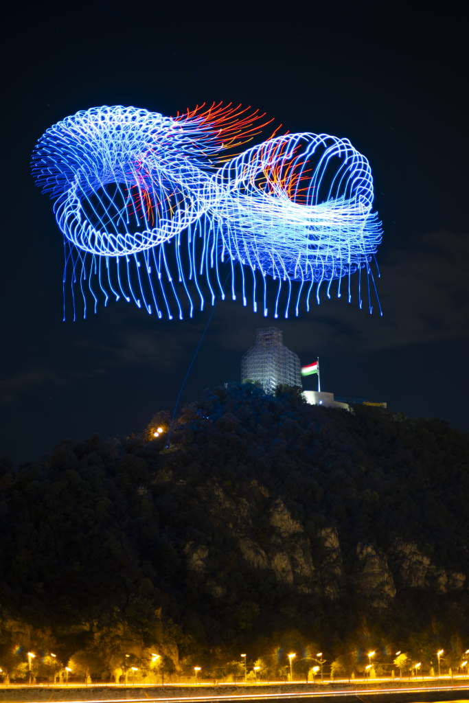 Abstract light trails forming swirling patterns against a dark night sky.