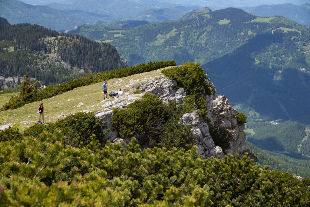 Hikers resting on a mountain plateau overlooking a valley.